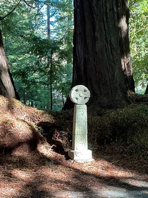 Cross monolith in a wooded area